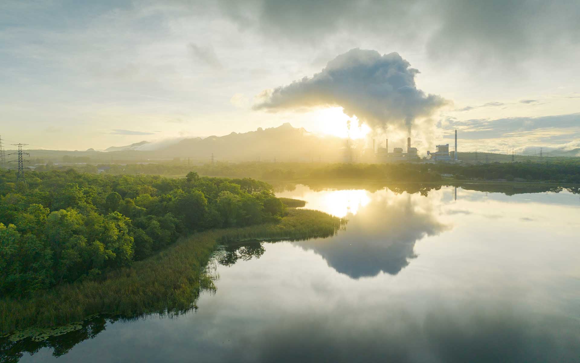 Industrieanlage am Fluss im Morgennebel